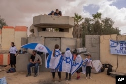 People gather at Israel's Nitzana border crossing with Egypt in southern Israel, on Feb. 27, 2024, protesting the delivery of humanitarian aid to the Gaza Strip until all hostages held by Hamas militants are released.