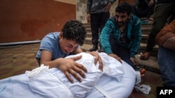 A Palestinian mourns over the body of a relative killed in Israeli strike at the Nasser hospital in Khan Younis on the southern Gaza Strip, Dec. 28, 2023.