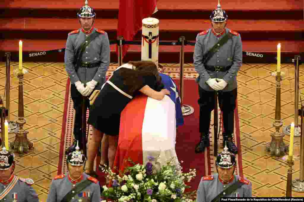 Magdalena and Cecilia Pinera, daughters of Chile's former President Sebastian Pinera, mourn over their father's coffin, at the former National Congress building, in Santiago, Feb. 7, 2024.
