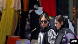 Women shop in Tehran on July 18, 2023, as the police relaunched patrols to catch women leaving their hair uncovered in public. Actress Afsaneh Bayegan received a suspended two-year prison sentence on July 19, 2023, for not wearing the compulsory hijab.