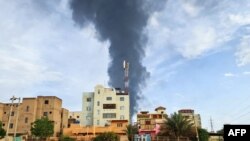 Smoke billows behind buildings amid ongoing fighting in Khartoum on June 9, 2023. 