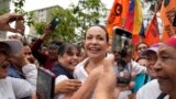Supporters embrace opposition leader Maria Corina Machado during a rally in San Antonio, Venezuela, April 17, 2024. The Biden administration on Wednesday reimposed oil sanctions on Venezuela, admonishing Nicolas Maduro's efforts to consolidate his rule.