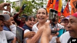 FILE - Supporters embrace opposition leader Maria Corina Machado during a rally in San Antonio, Venezuela, April 17, 2024. She has called for hundreds of demonstrations Aug. 17, 2024, against the election victory claimed by Nicolas Maduro,