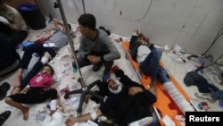 FILE - Wounded Palestinians are assisted at Nasser hospital, following Israeli strikes on Ma'an school east of Khan Younis, in Khan Younis in the southern Gaza Strip, Dec. 5, 2023.