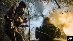 A Ukrainian policeman of a special police unit fires a D-30 cannon toward Russian positions at the front line, near Kreminna, Luhansk region, Ukraine, July 7, 2023. 