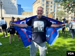 Un seguidor del Donald Trump viste una camiseta con la foto policial del expresidente durante una vigilia en la ciudad de Milwaukee para rezar por la salud y seguridad del candidato presidencial republicano, víctima de un atentado el día anterior en un mitin de campaña.