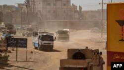 Sudanese army armored vehicles drive in a street in Khartoum, on June 26, 2023. 