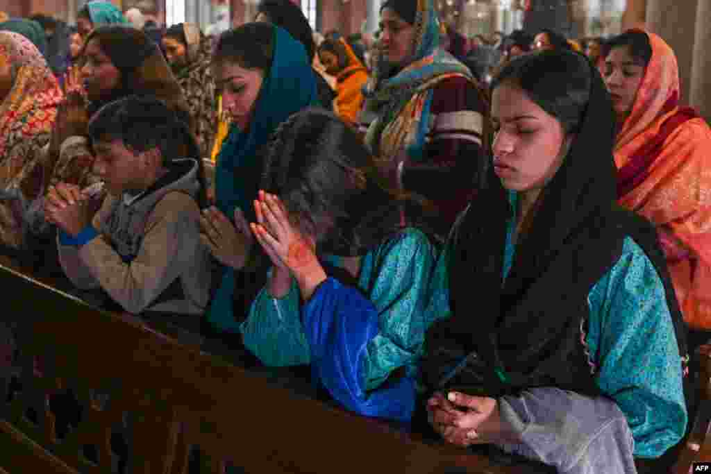 Christian devotees pray at a Christmas mass in the Sacred Heart Cathedral in Lahore on December 25, 2023.