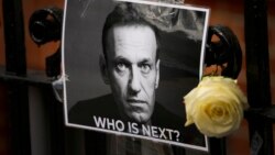 Sekuntum bunga dan foto yang diletakan sebagai penghormatan kepada politisi Rusia Alexey Navalny, di dekat Kedutaan Besar Rusia di London, 18 Februari 2024. (Foto: AP)
