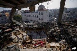 FILE - Palestinians look at a damaged residential building after an Israeli strike in Rafah, Gaza Strip, Jan. 10, 2024. The White House on Feb. 8, 2024, cautioned Israel against carrying its military campaign into Rafah.