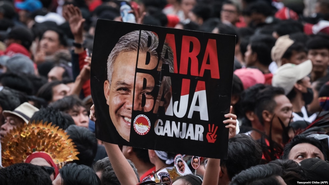 Seorang pendukung mengangkat poster calon presiden dan mantan gubernur Jawa Tengah Ganjar Pranowo saat kampanye pemilu di Stadion Gelora Bung Karno, Jakarta pada 3 Februari 2024. (Foto: Yasuyoshi Chiba/AFP)