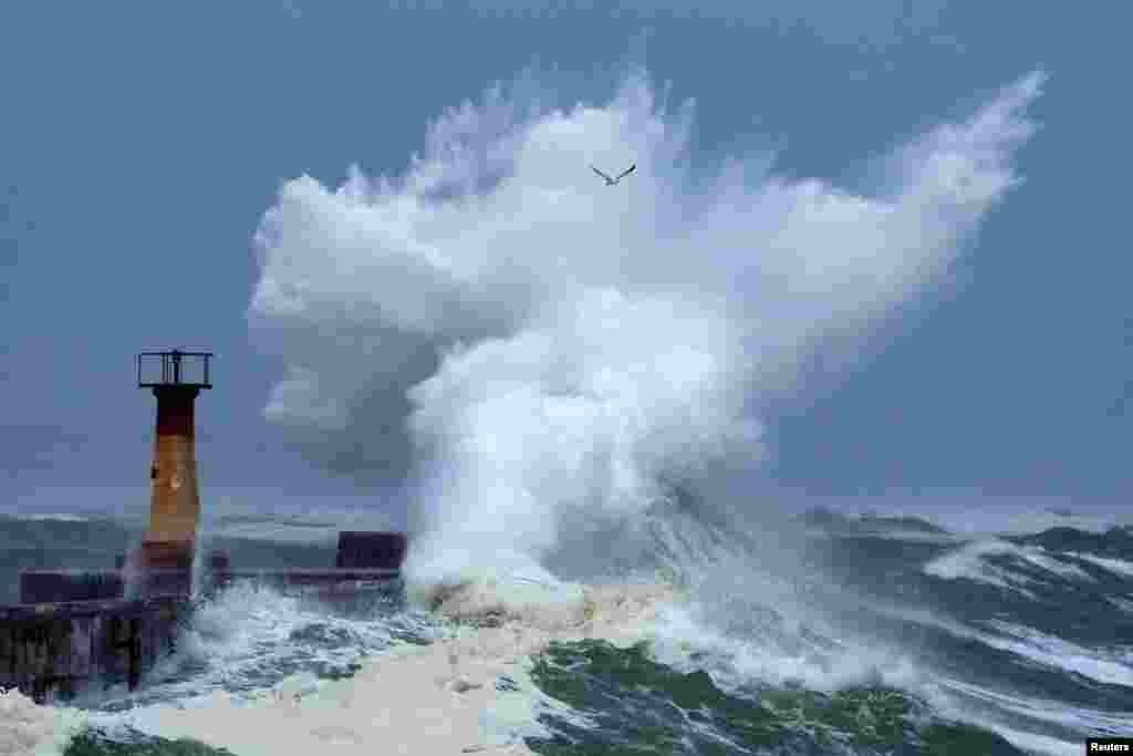 A storm swell breaks over Kalk Bay harbor during severe weather in Cape Town, South Africa.