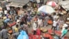 FILE - Pedestrians shop for peppers and other food at the Mile 12 Market in Lagos, Nigeria, on Feb. 16, 2024. The nation's inflation rate fell slightly in August, but Nigerians are still hampered by high prices.