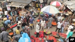 FILE - Pedestrians shop for peppers and other food at the Mile 12 Market in Lagos, Nigeria, on Feb. 16, 2024. The nation's inflation rate fell slightly in August, but Nigerians are still hampered by high prices.