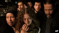 Palestinian activist Ahed Tamimi, center, is supported by her mother after she was released from prison by Israel, in the West Bank town of Ramallah, Nov. 30, 2023.