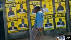 A boy leans near to campaign posters with images of candidates in Harare, Zimbabwe, on July 16, 2023.