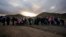 Asylum-seeking migrants line up in a makeshift, mountainous campsite to be processed after crossing the border with Mexico, Feb. 2, 2024, near Jacumba Hot Springs, California.