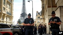 FILE - Police officers gather in a street near the Eiffel Tower on the eve of the Paralympic Games opening ceremony, Aug. 27, 2024 in Paris.