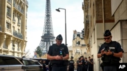 Police officers gather in a street near the Eiffel Tower on the eve of the Paralympic Games opening ceremony, Aug. 27, 2024 in Paris.