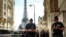 Police officers gather in a street near the Eiffel Tower on the eve of the Paralympic Games opening ceremony, Aug. 27, 2024 in Paris.