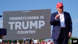 Op foto's: Trump vluchtte het podium tijdens een bijeenkomst na een schijnbare moordaanslag