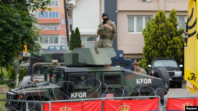 FILE - U.S. members of the NATO-led Kosovo Force (KFOR) stand guard outside municipal offices in Leposavic, Kosovo, June 2, 2023.