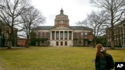 FILE - Students walk by the Rush Rhees Library at the University of Rochester on Feb. 22, 2023. 