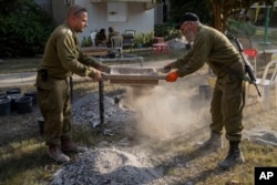 IDF soldiers from the Israeli military rabbinate try to find items that will help identify people killed at Kibbutz Nir Oz, Israel, near the Gaza Strip, Nov. 9, 2023.