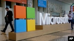 FILE - A man walks past a Microsoft sign set up for the Microsoft BUILD conference, April 28, 2015, at Moscone Center in San Francisco. (AP Photo)