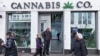 FILE - People pass by a cannabis shop in midtown Manhattan in New York on March 19, 2024. 