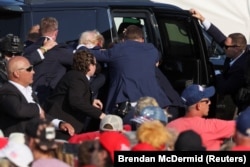 Mantan Presiden AS Donald Trump masuk ke dalam kendaraan dengan bantuan Secret Service AS setelah ditembak di telinga kanannya saat kampanye di di Butler, Pennsylvania, AS, 13 Juli 2024. (Foto: REUTERS/Brendan McDermid)