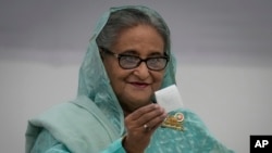 FILE - Bangladesh Prime Minister Sheikh Hasina shows her ballot paper as she casts her vote in Dhaka, Bangladesh, Jan. 7, 2024.