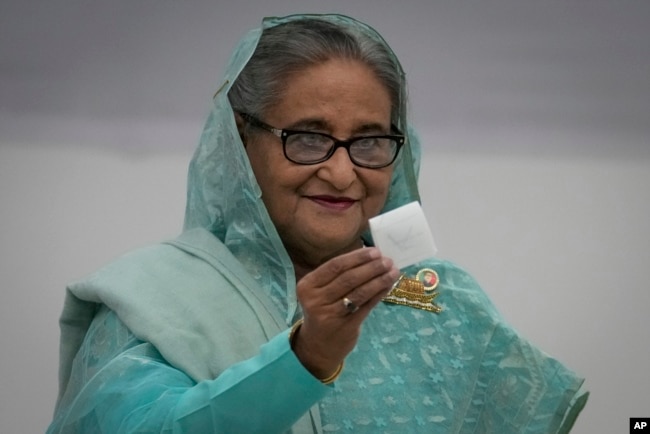 FILE - Bangladesh Prime Minister Sheikh Hasina shows her ballot paper as she casts her vote in Dhaka, Jan. 7, 2024.