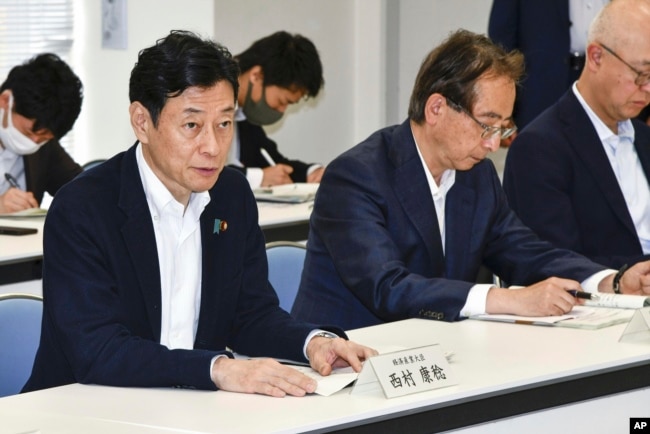 Japan's Industry Minister Yasutoshi Nishimura, left, meets with fisheries officials, not in photo, in Iwaki, Fukushima prefecture, northern Japan, Saturday, June 10, 2023. (Kyodo News via AP)