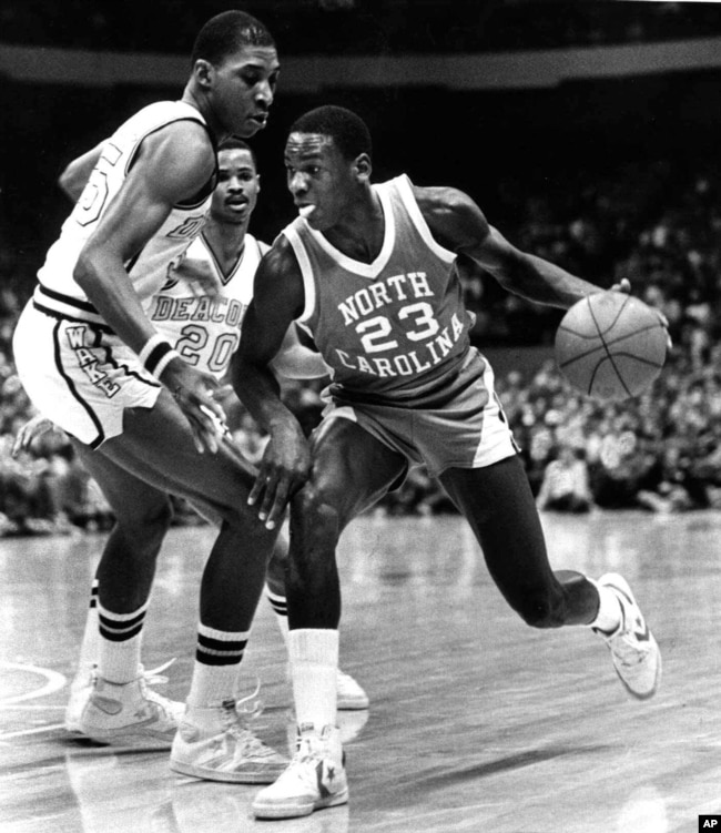 In this Feb. 17, 1982, file photo, North Carolina's Michael Jordan (23) drives around the defense of Wake Forest's Anthony Teachey, left, and Danny Young (20) at the Greensboro Coliseum in Greensboro, N.C. (AP Photo/Bob Jordan, File)