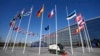 Ein leerer Fahnenmast steht am 3. April 2023 vor dem NATO-Hauptquartier in Brüssel zwischen den Nationalflaggen Frankreichs und Estlands. Finnland wird am Dienstag offiziell der NATO beitreten.