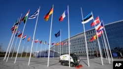An empty flagpole stands between the national flags of France and Estonia outside NATO headquarters in Brussels, April 3, 2023. Finland will officially entry into NATO on Tuesday.