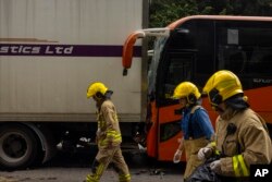 Tim SAR memeriksa lokasi sekitar kecelakaan di jalan raya Hong Kong, Jumat, 24 Maret 2023. (AP/Louise Delmotte)