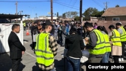 在丁胖子廣場附近，志工發給新到來的移民食品和衣物。 （2024年4月6日，王中偉提供）