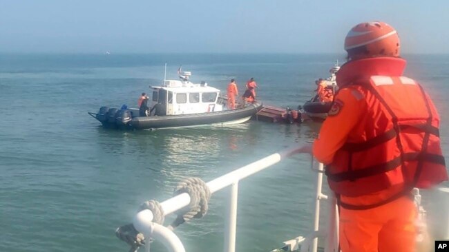 In this handout photograph provided by Taiwan Coast Guard Administration, Taiwanese coast guards inspect a vessel that capsized during a chase off the coast of Kinmen archipelago in Taiwan, Feb. 14, 2024.