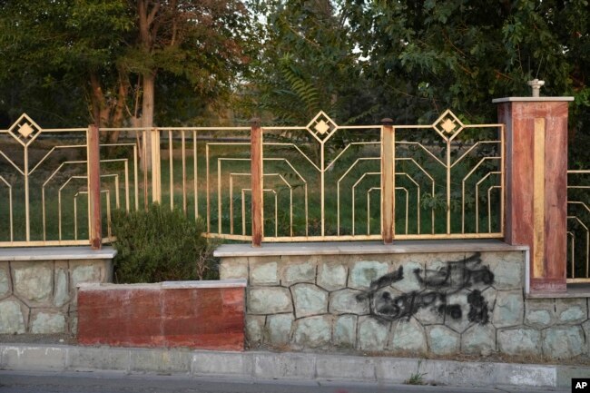 A graffiti against the government which is painted over in black is seen on the wall at a park in Tehran, Iran, Sept. 11, 2023.