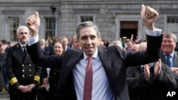 The new Prime Minister of Ireland, Simon Harris, gestures as he is applauded by fellow lawmakers outside Leinster House, in Dublin, Ireland, April 9, 2024. 