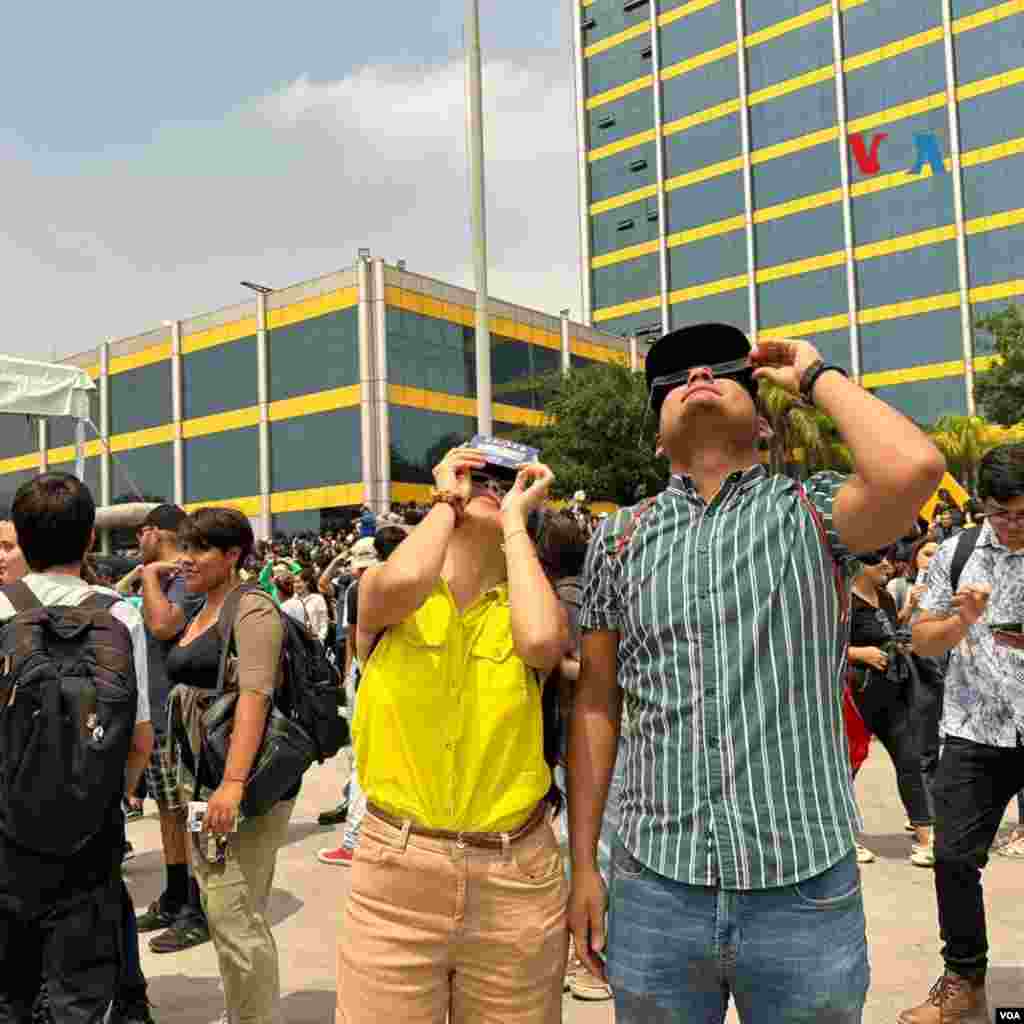 Mexicanos en la explanada de la Universidad Autónoma de Nuevo León miran el eclipse de sol que tuvo un 95 % de visibilidad cerca de la frontera con EEUU.