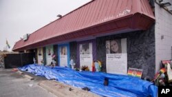 FILE - The exterior of Club Q is seen with tributes to five patrons killed there in a November 2022 shooting, in Colorado Springs, Colorado, Feb. 22, 2023. 