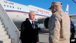 FILE - Russian President Vladimir Putin listens the report of Col. Gen. Sergei Surovikin, Russian Commander in Syria, at the Hemeimeem air base in Syria, on Dec. 11, 2017.