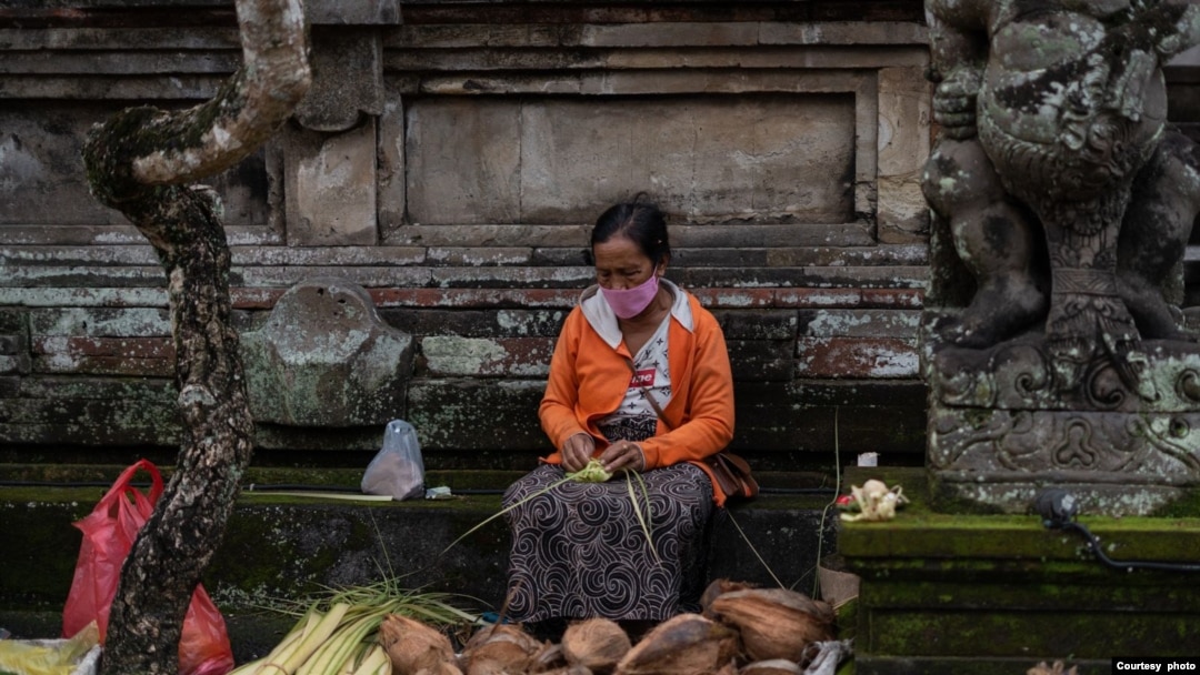 Seorang penjual janur dan kelapa menjajakan dagangannya di salah satu area di Bali, pada 24 Februari 2024, menjelang perayaan Hari Raya Galungan. (Foto: Courtesy of Dwina Maheswara)