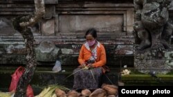 Seorang penjual janur dan kelapa menjajakan dagangannya di salah satu area di Bali, pada 24 Februari 2024, menjelang perayaan Hari Raya Galungan. (Foto: Courtesy of Dwina Maheswara)