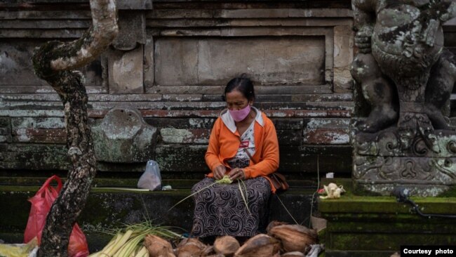 Seorang penjual janur dan kelapa menjajakan dagangannya di salah satu area di Bali, pada 24 Februari 2024, menjelang perayaan Hari Raya Galungan. (Foto: Courtesy of Dwina Maheswara)