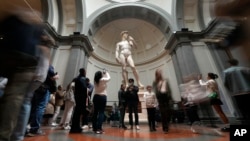 Visitors admire Michelangelo's "David" statue in the Accademia Gallery in Florence, Italy, Tuesday, March 28, 2023. (AP Photo/Alessandra Tarantino)