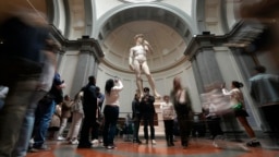 Visitors admire Michelangelo's "David" statue in the Accademia Gallery in Florence, Italy, Tuesday, March 28, 2023. (AP Photo/Alessandra Tarantino)